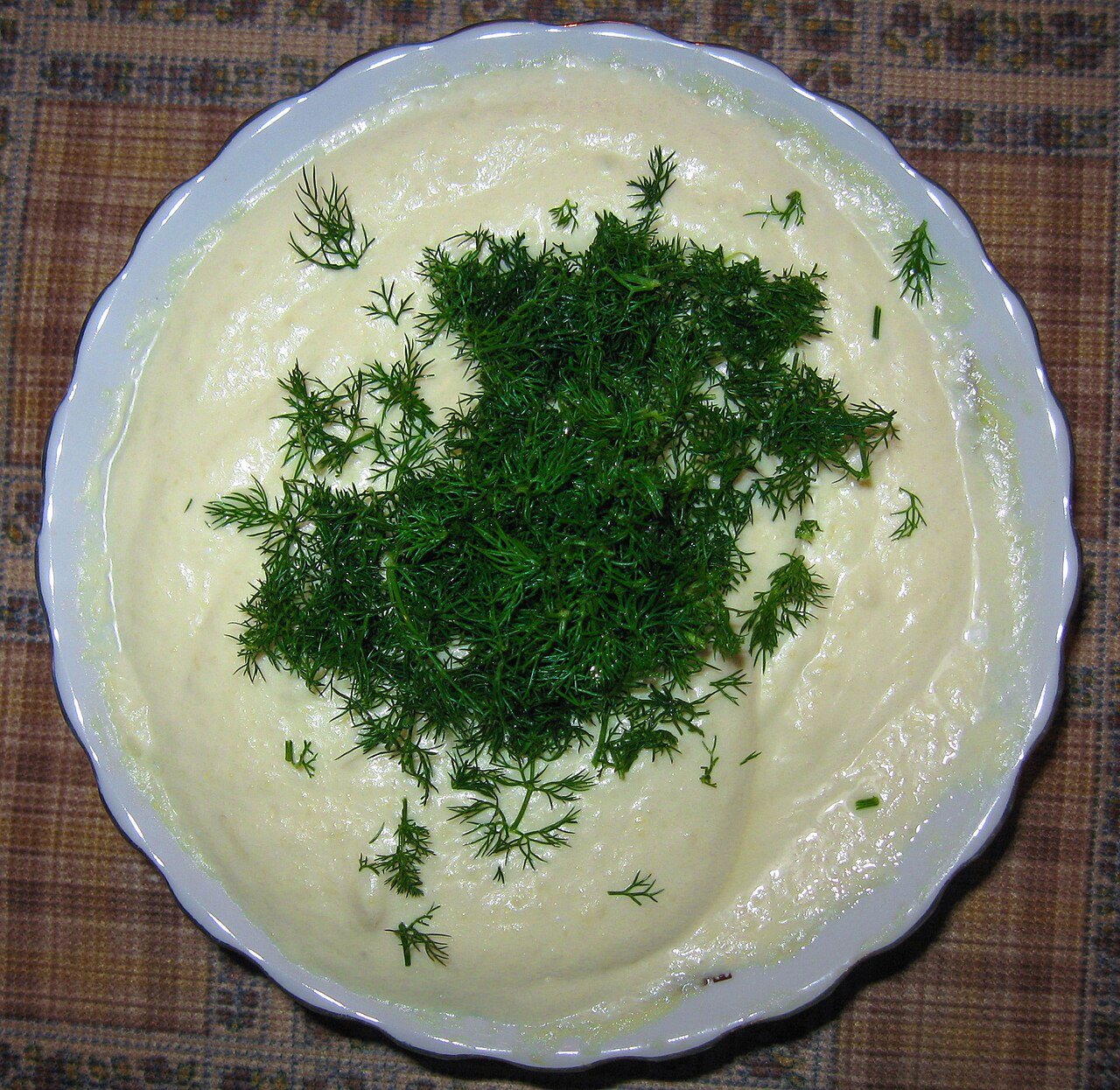 סלט קיופולו לבן עם מיונז ומעליו מצע של שמיר ירוק טרי בקערה