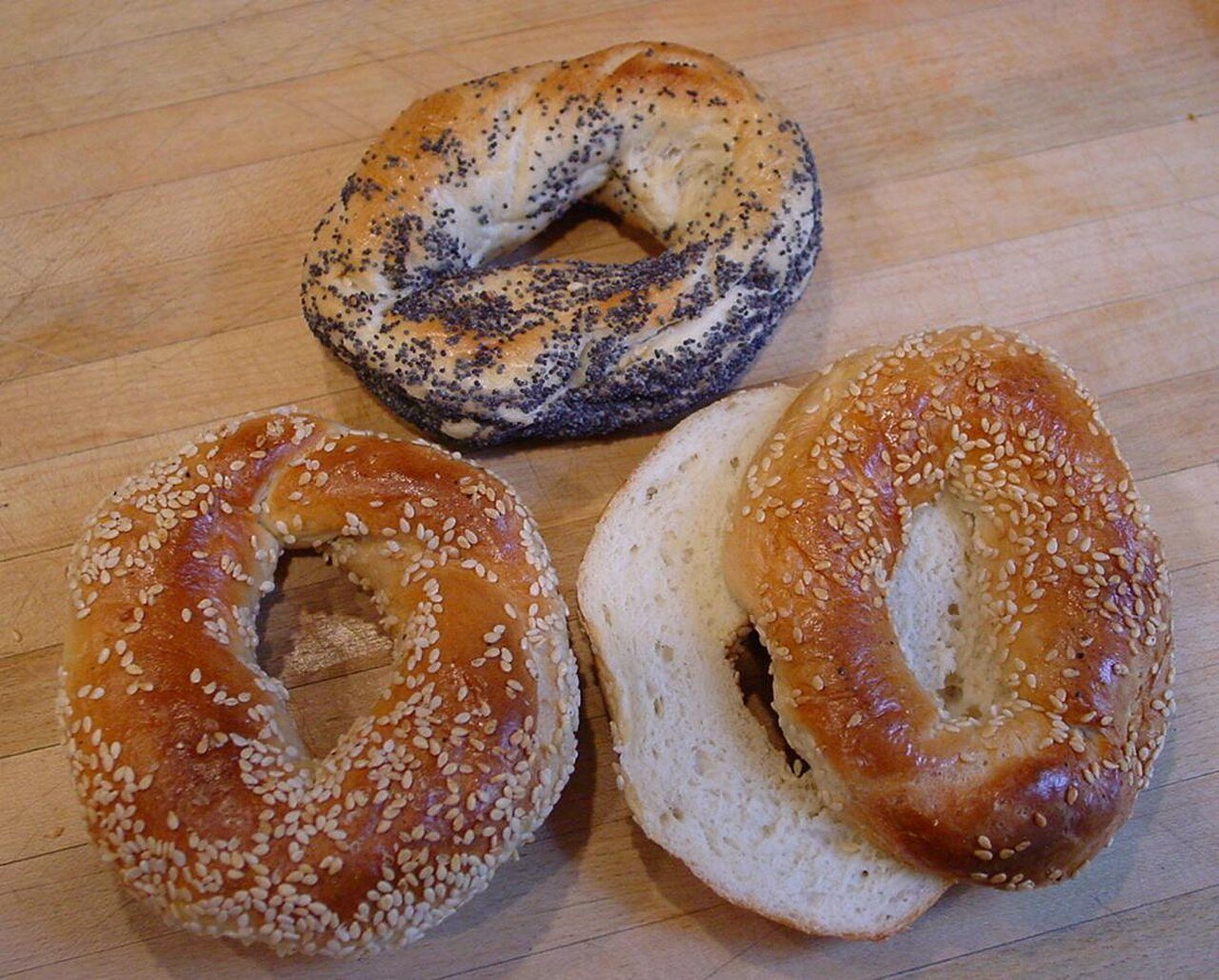 בייגלס עם ציפוי שומשום וציפוי פרג מונחים על קרש עץ