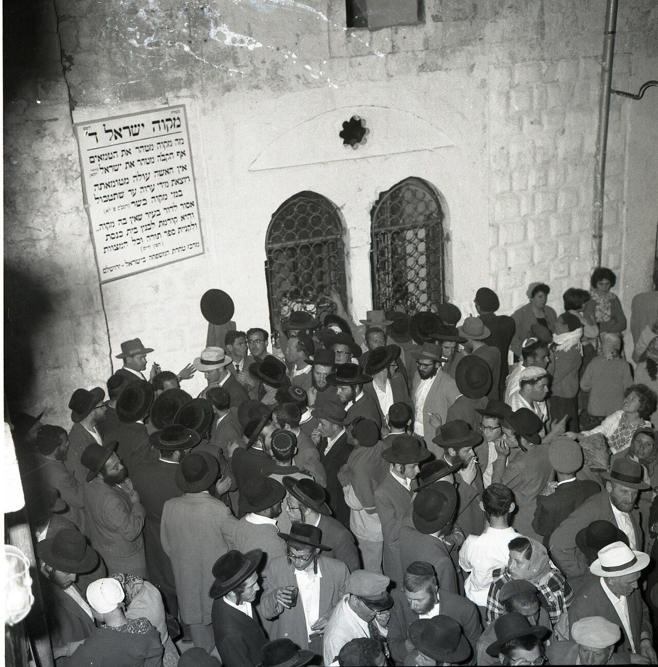 תצלום שחור לבן של המון מול בניין אבן